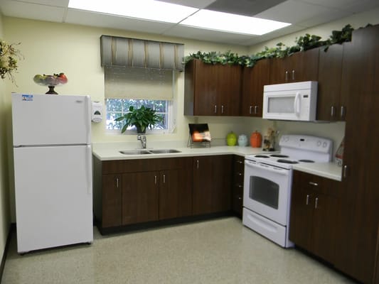 Bright and functional kitchen with a refrigerator, stove, and cabinets.