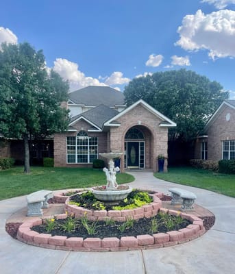 A fountain surrounded by flower beds and benches at Wedgewood South.
