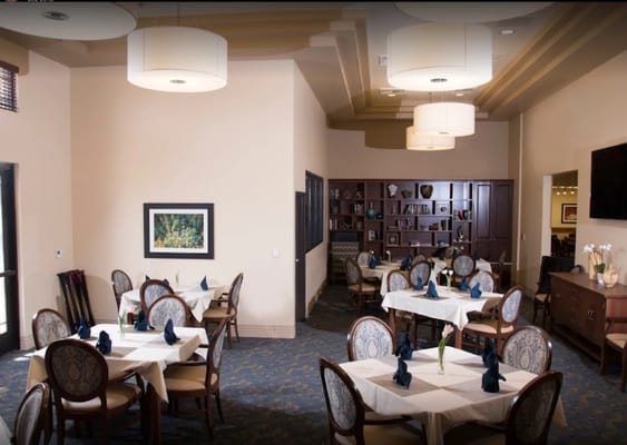 Cozy dining room setup with neatly arranged tables and decorative chairs.