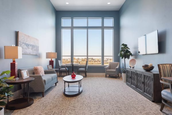 Bright common area with large windows and cozy seating