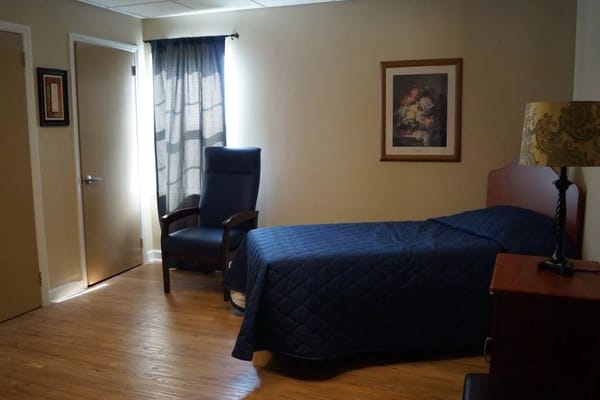 Bright private room with a bed and chair