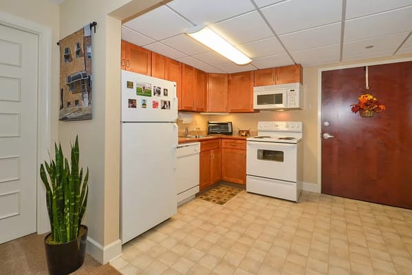 Bright kitchen area with wood cabinetry and appliances