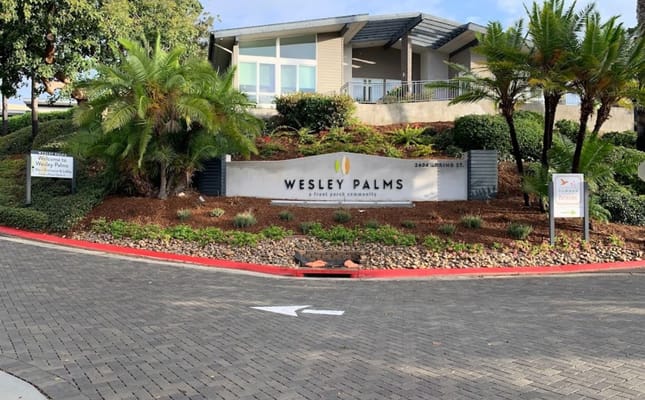 Exterior view of Wesley Palms entrance with landscaping