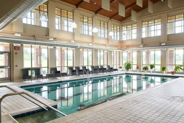 Indoor pool area with lounge seating and large windows