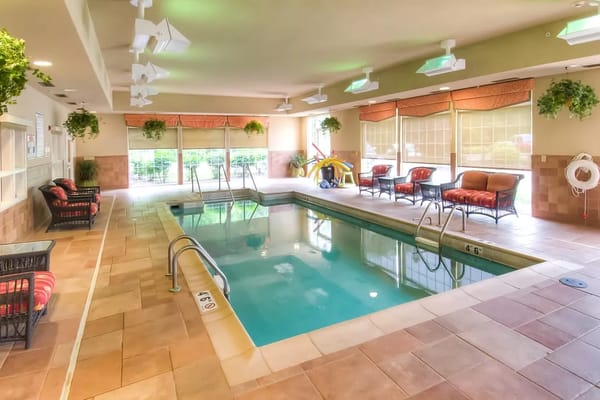Indoor swimming pool area with seating and plants