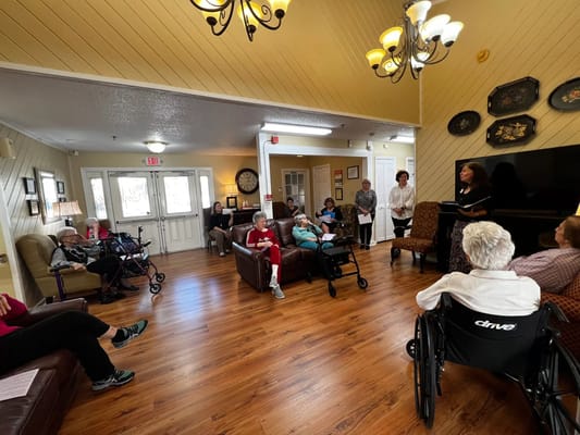 Seniors participating in a group activity inside Whispering Pines Personal Care Home.