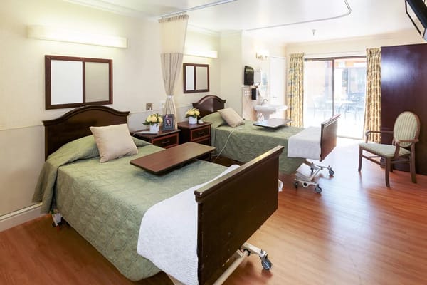 A well-furnished shared resident room with beds and seating