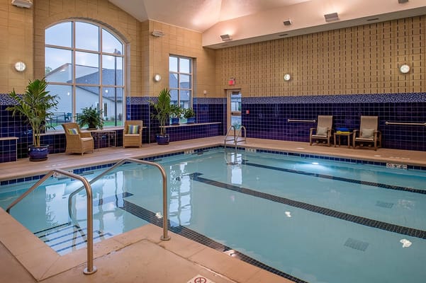 Indoor pool area with seating and plants
