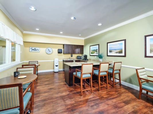 Bright kitchen common area with seating and a counter