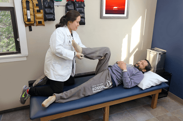 Therapist assisting a resident with leg exercises