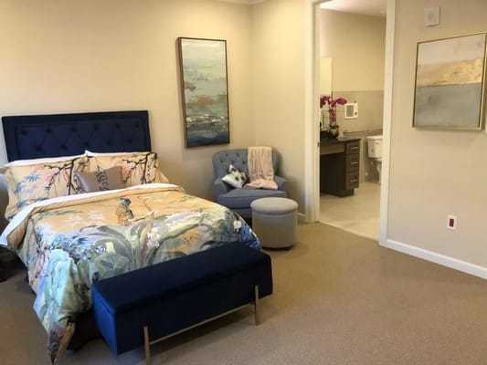 Private bedroom featuring a bed, seating area, and bathroom entrance.