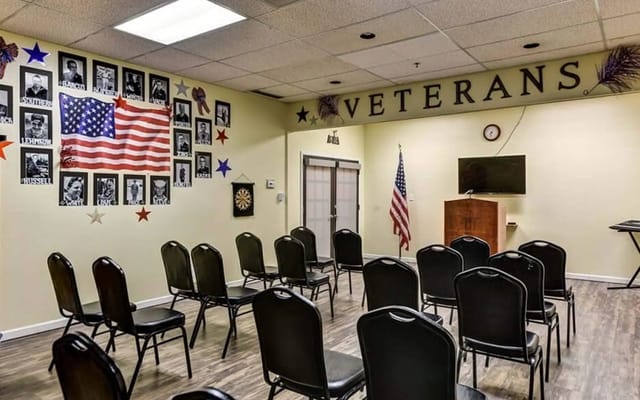 Seating area in the Veterans' Room with American flag and photos on the wall