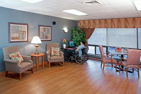 A cozy common area with a resident at the computer