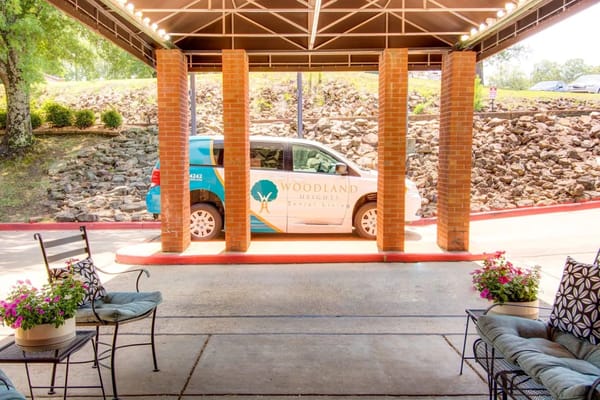 Woodland Heights senior living facility entrance with a van parked