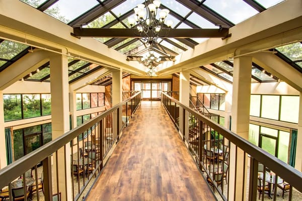 Interior walkway with large windows and chandeliers at Woodland Heights