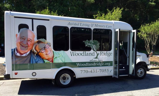 Bus for Woodland Ridge Assisted Living with images of happy seniors.