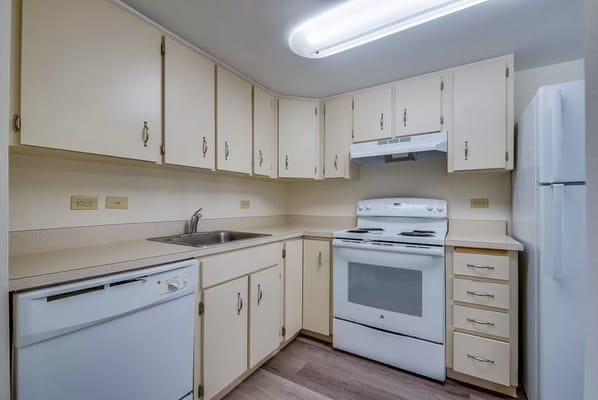 Bright kitchen with white appliances and cabinetry