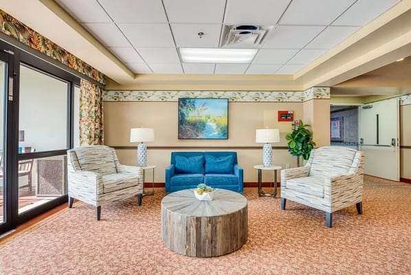 Bright and inviting lounge area with blue couch and floral decor.
