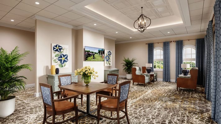 A cozy common room featuring a dining table, comfy chairs, and decorative plants.