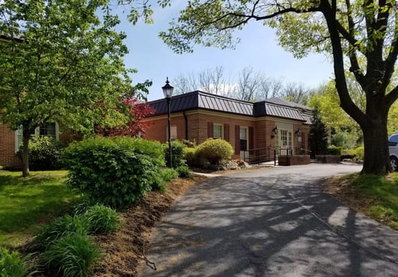 Exterior view of a senior living facility surrounded by trees