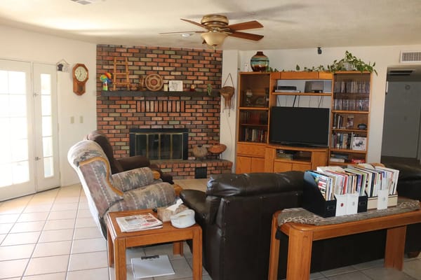Spacious living room featuring comfortable seating and a brick fireplace