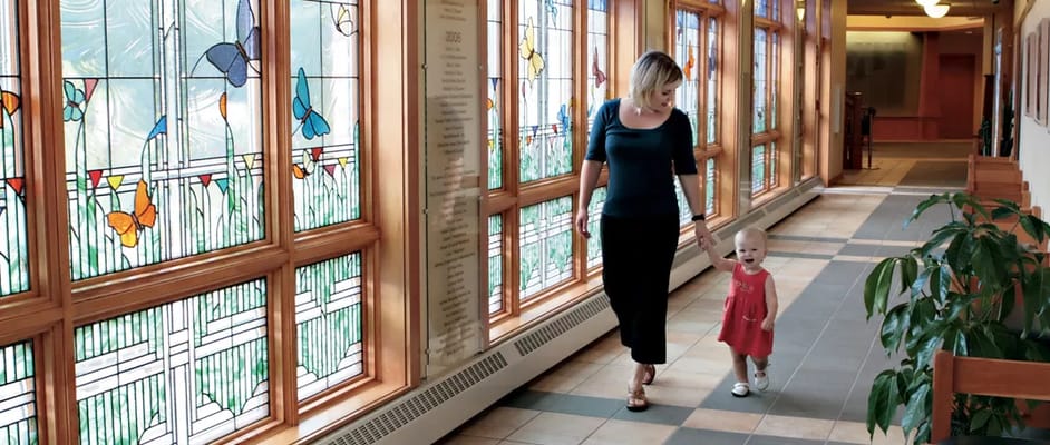 A woman and child walking in a brightly lit hallway