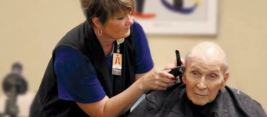 Staff providing a haircut to a resident in a salon