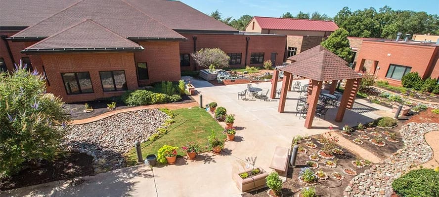 View of the landscaped courtyard with seating areas and flower beds.