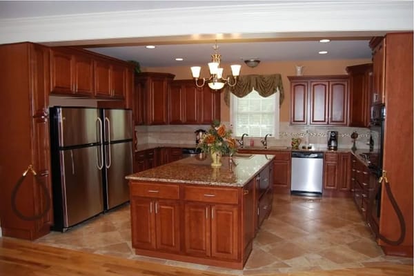 Bright kitchen area with wooden cabinetry and appliances.