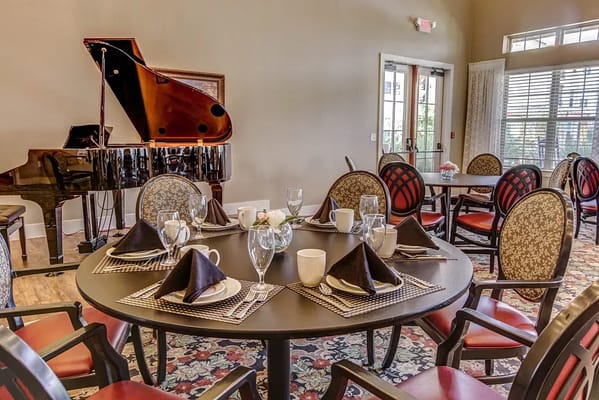 Elegant dining room setup with piano and table settings