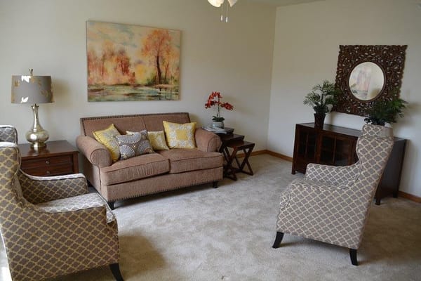 Cozy living room with a sofa and armchairs at Aster Place.