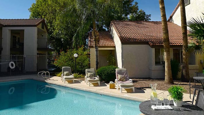 A sunny outdoor pool area with lounge chairs