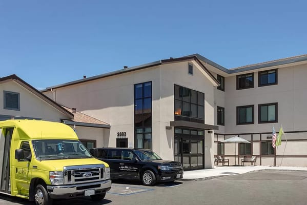 Exterior view of Atria Park of San Mateo with facility vehicles