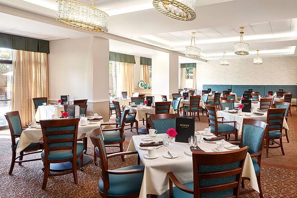 Dining room with elegantly set tables and chairs