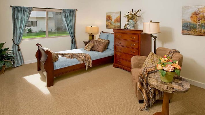 Cozy private room with bed, dresser, and seating