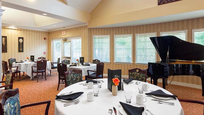 Elegant dining room setup with a piano and floral centerpiece