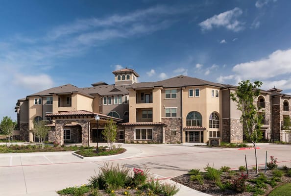Exterior view of a senior living facility with landscaped entrance