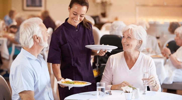 A dining room scene with residents and staff enjoying a meal
