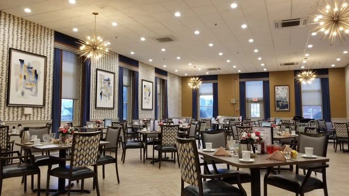 Dining room with tables set for meals and floral centerpieces