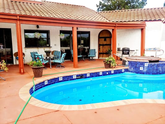 Outdoor pool area with seating and plants