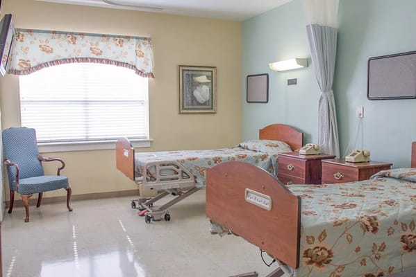 A shared resident room with two beds and a sitting area