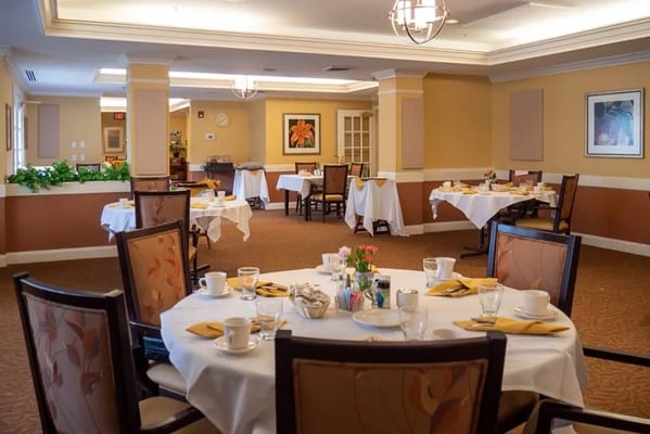 Brightly lit dining room with tables set for meals