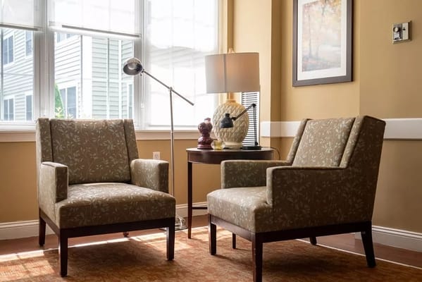 Two comfortable chairs and a lamp in a sunny living room