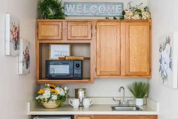 Cozy kitchenette with floral decorations and a welcome sign