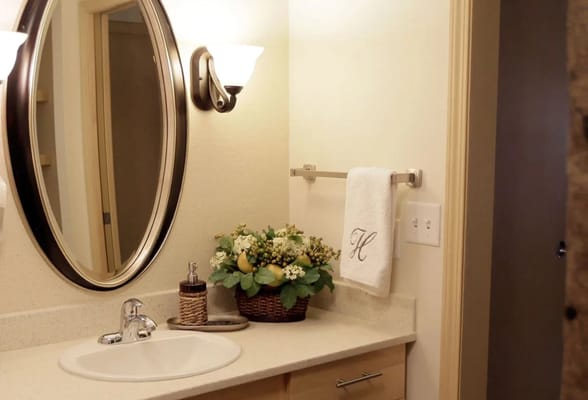 Brightly lit bathroom with decorative plants and mirror