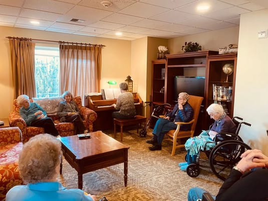 Residents enjoying a piano session in a common area