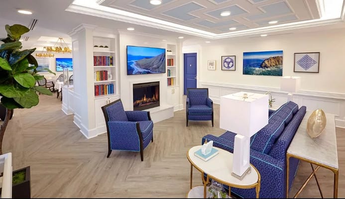 Bright living room with seating and bookshelf at The Bristal Assisted Living.