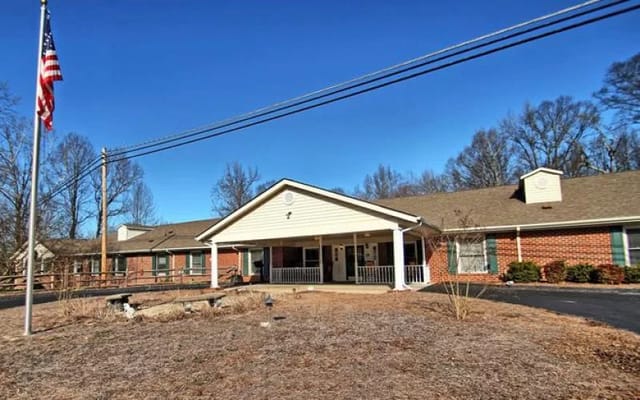 Front exterior of a senior living facility with flag