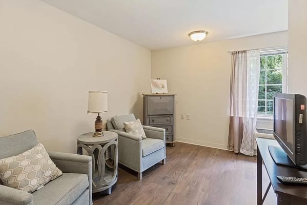 Interior view of a resident room with two chairs and a television