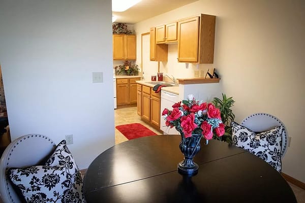 Cozy dining area with a round table and floral centerpiece.